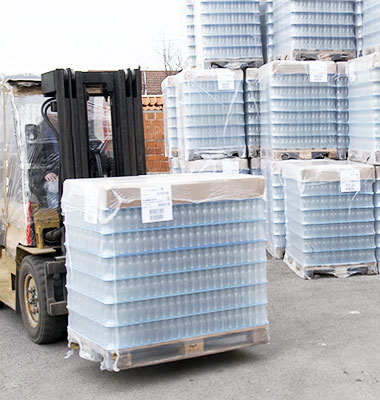forklift transporting packaged bottles outside